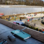 Blick vom Balkon auf den Utopiastadt-Campus. Auf dem Balkonsims liegt ein Notizbuch mit der Aufschrift »LOGBUCH«