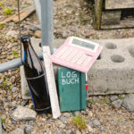 Zollstock, Bierchen, Taschenrechner, Notizbuch mit Aufschrift »LOGBUCH«