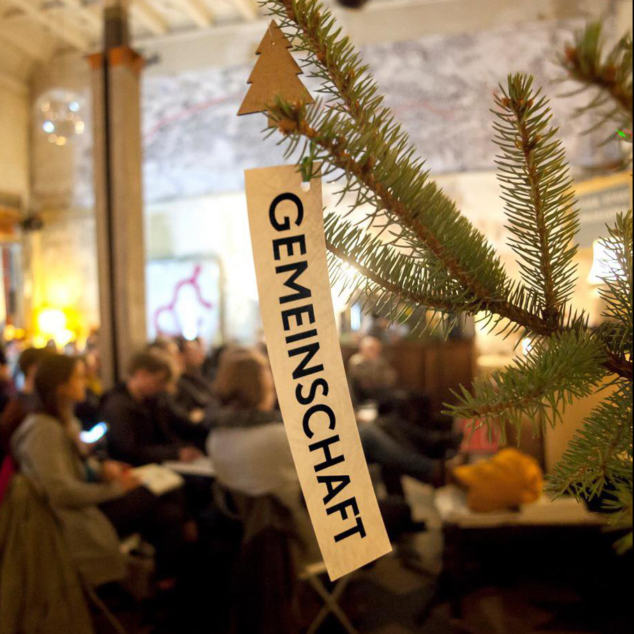 Tannenzweig mit Weihnachstsschmuck und der Aufschrift »Gemeinschaft«