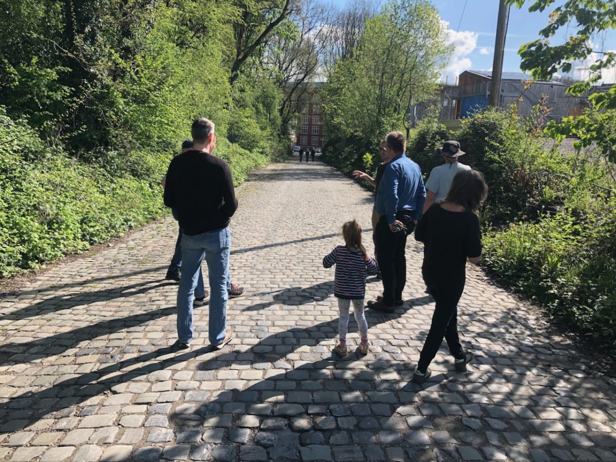 Einige Menschen blicken den Weg vom Utopiastadt-Campus zur Hamburger Straße hinab.